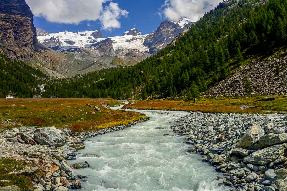 Un fiume di montagna con sullo sfondo una montagna con ghiacciai