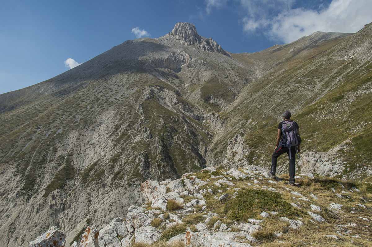Escursionista che osserva da valle la vetta del Monte Camicia